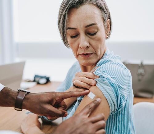 Woman getting a bandage after a vaccine