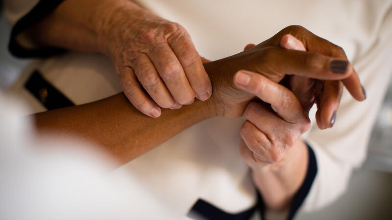 Caregiver holding a woman's wrist