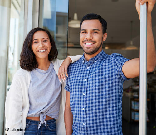 Couple standing outside their house