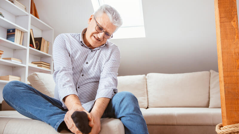 Man holding painful foot