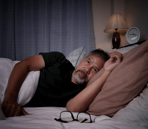 Adult man awake in bed