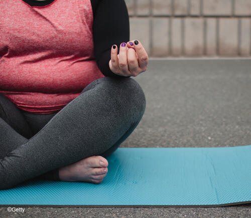 Plus sized woman doing yoga.