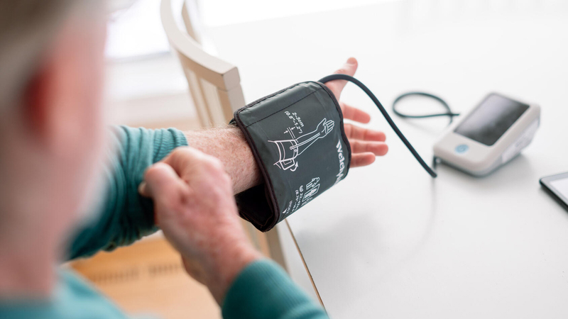 Person putting on blood pressure cuff