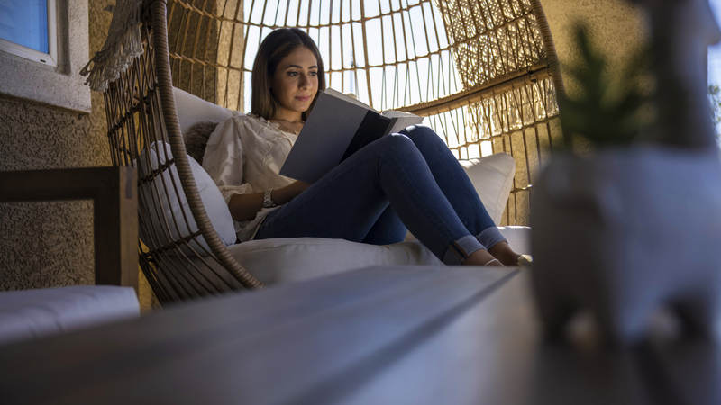 Woman in egg chair reading